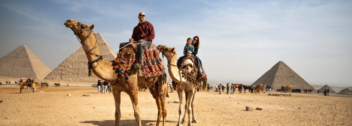 Famiglia sui cammelli davanti alle Piramidi di Giza
