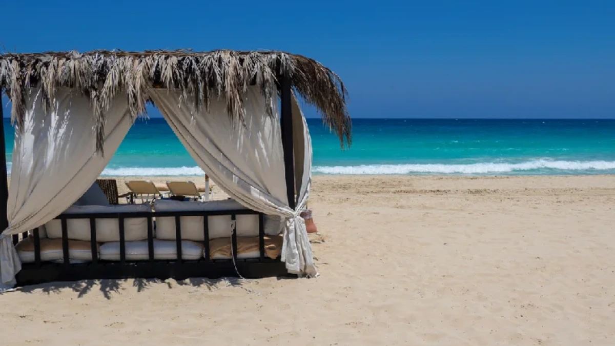 Ein eleganter Pavillon am Strand von Marsa Matruh in Ägypten mit türkisblauem, grün schimmerndem Mittelmeer und einer ruhigen, menschenleeren Küstenlandschaft.