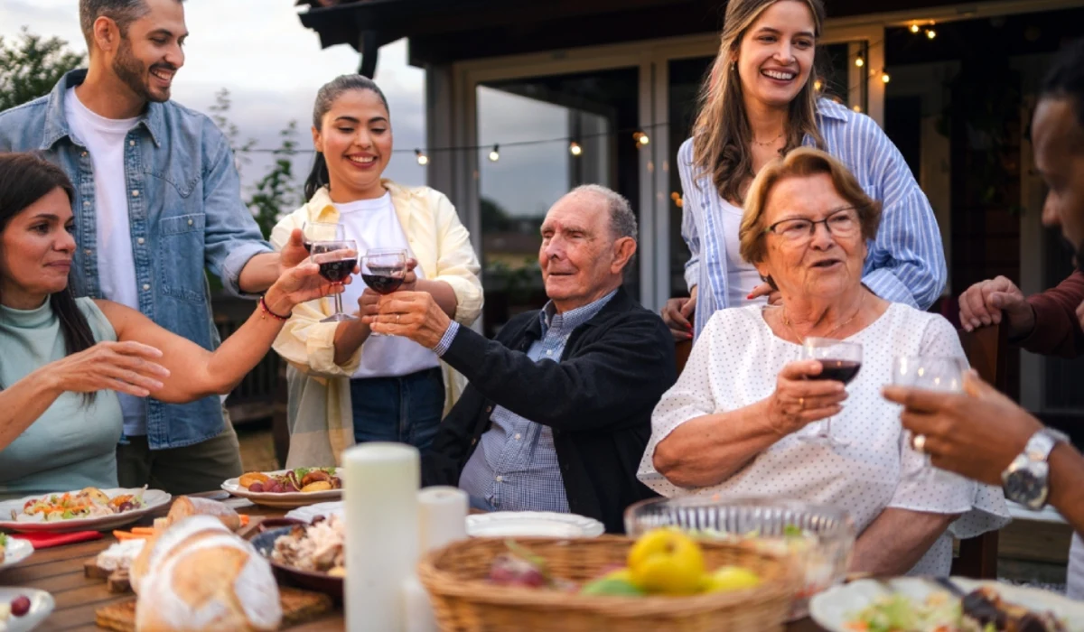 Friends raising wine glasses at outdoor dinner.
