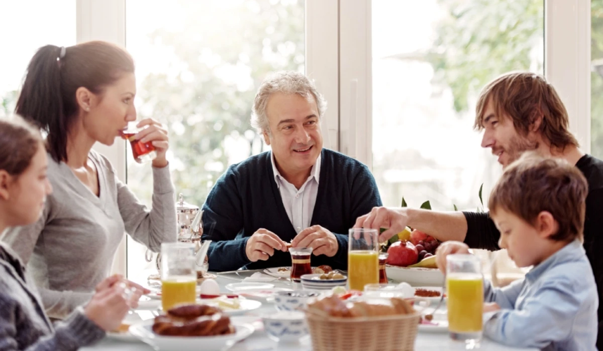 Group enjoying breakfast together at sunlit dining table.
