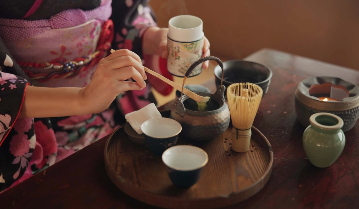 Traditional, matcha and Japanese woman with tea in home with herbs, powder and flavor in teapot. Ritual, indigenous culture and hand of person with herbal beverage for drinking, ceremony and wellness