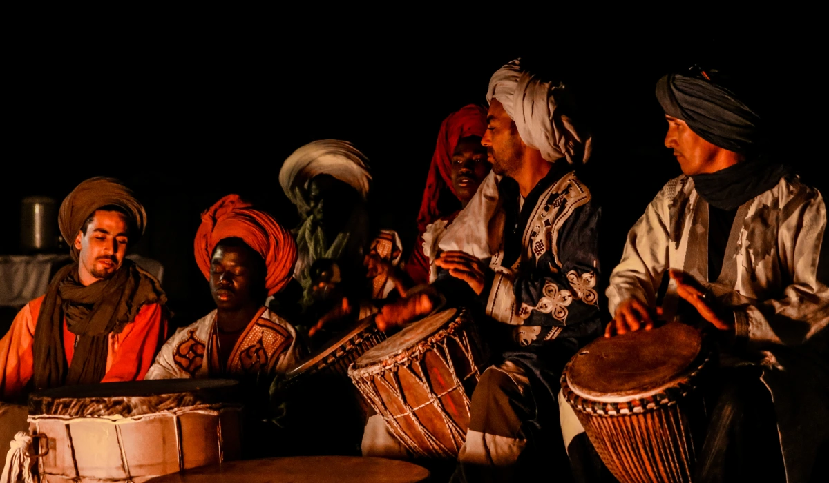 Bedouin’s playing drums in the light of a camp fire in the Sahara desert of Morocco near Erg Chebbi