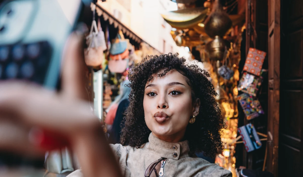 Young adult woman taking selfie in Marrakech souk
