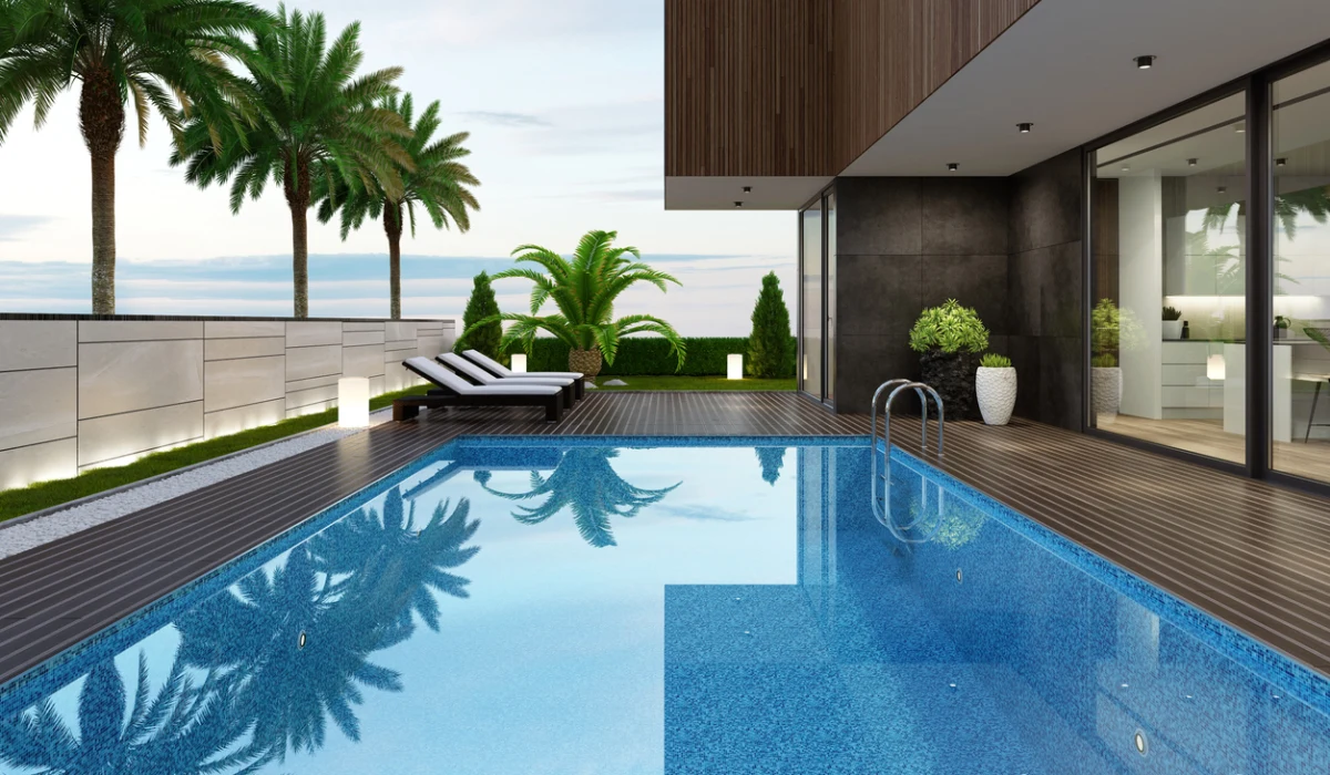 Luxurious beach side villa with swimming pool and palm trees at summer sunset scene