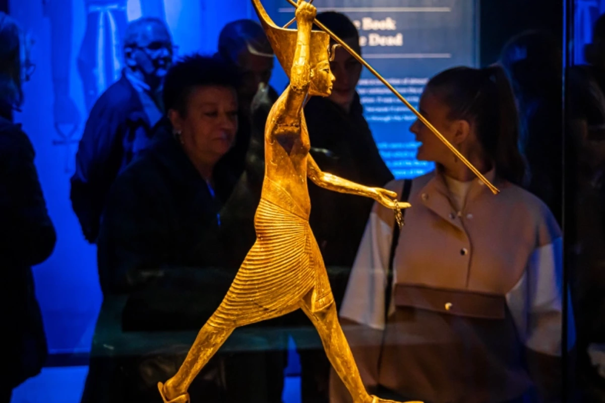 Vergoldete Statuette des Tutanchamun mit Harpune in einer Ausstellungsvitrine