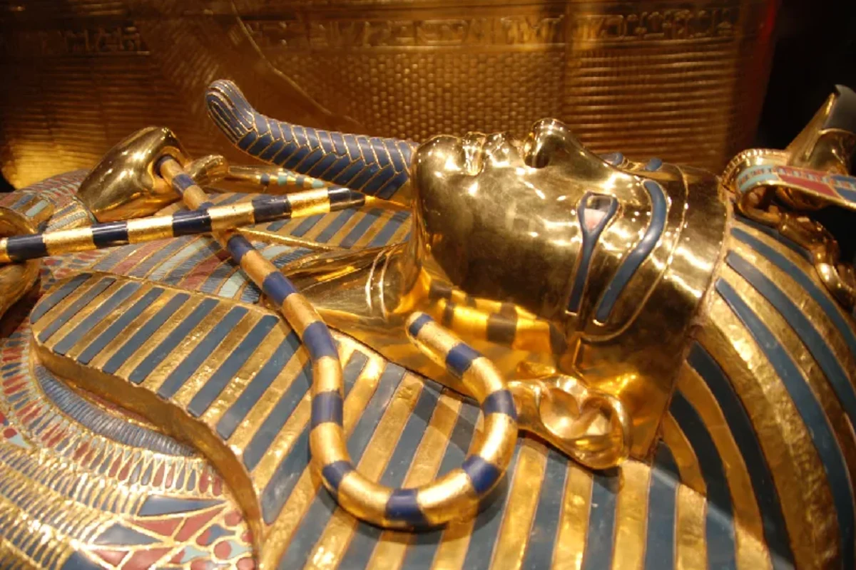 Vergoldeter Sarg des Tutanchamun mit blau-goldenem Nemes-Kopftuch und gekreuzten Insignien