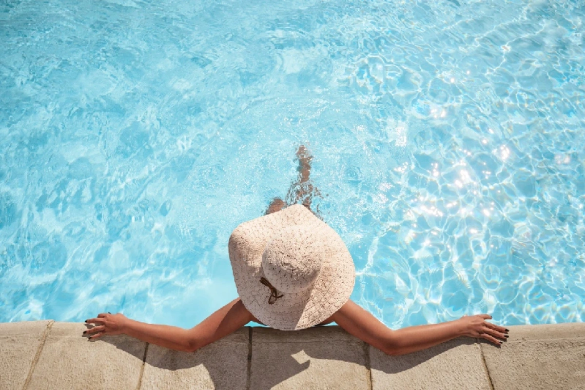 Junge Frau, die mit Kopierraum im Schwimmbad entspannt