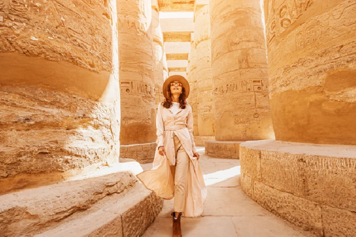 Touristin erkundet die monumentalen Säulen des Karnak-Tempels in Luxor, Ägypten