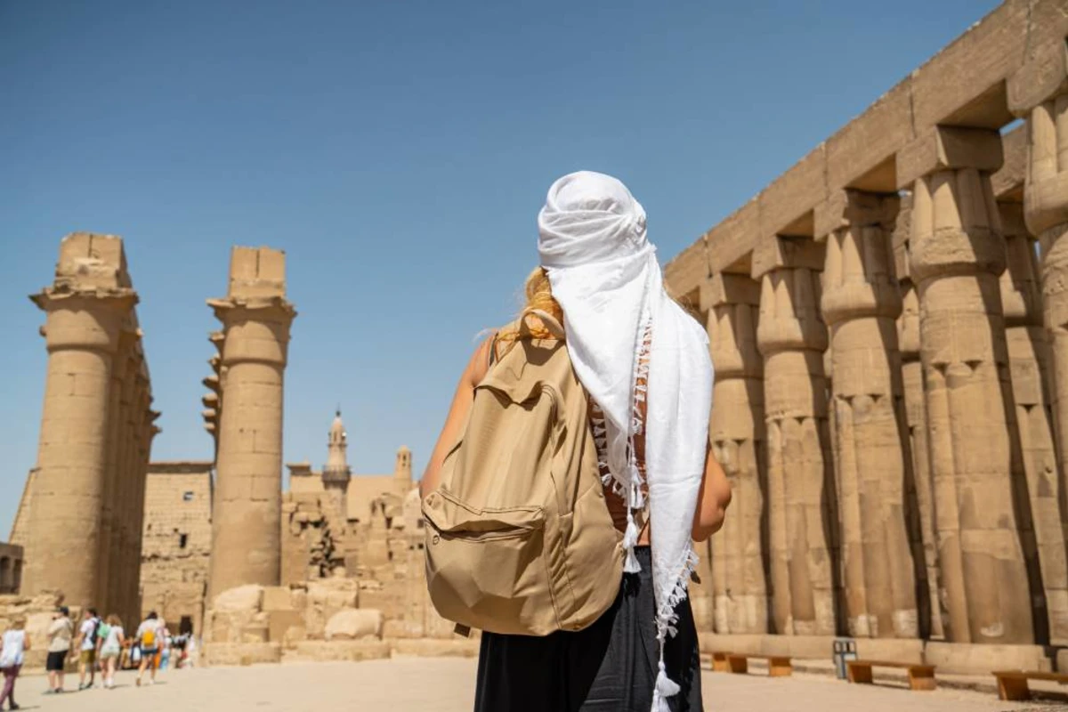 Traveller in a white headscarf standing before the columns of Luxor Temple on a Nile cruise shore excursion