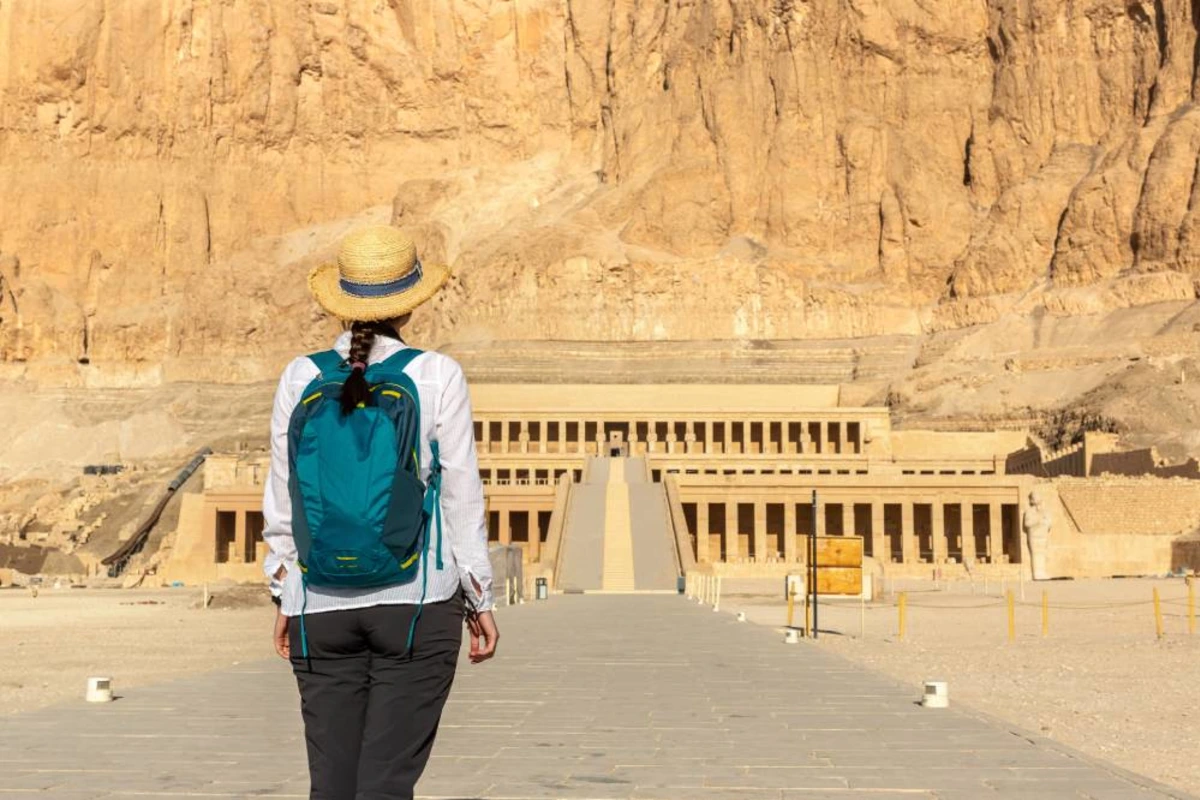 Woman in a straw hat looking at the Temple of Hatshepsut at Deir el-Bahari on the Luxor West Bank