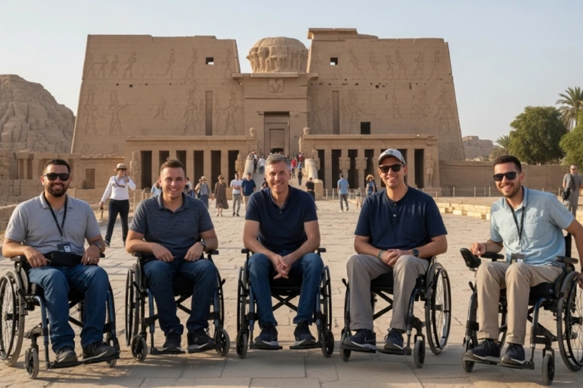   Five wheelchair users smile in front of the Temple of Horus at Edfu, framed by ancient carvings and clear skies—celebrating accessible tourism at a historic Egyptian site.