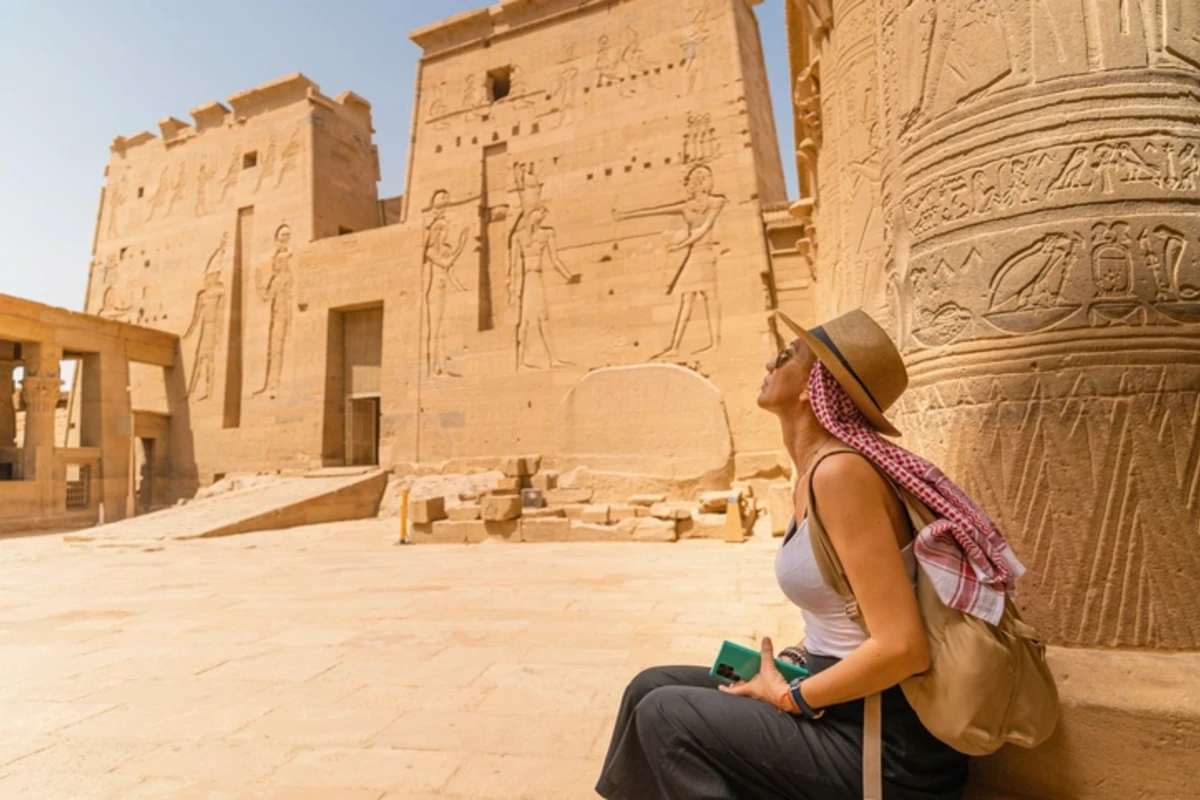 Woman sitting in Temple of Philae aka Temple of Isis in Aswan Egypt, Egypt Vacation Package