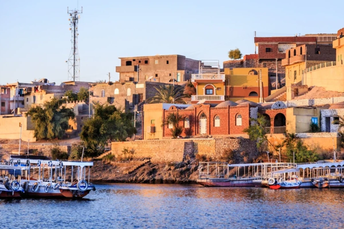 Wooden boats carrying passengers docked along the Nile River at the Temple of Philae in Aswan, Egypt Vacation Package