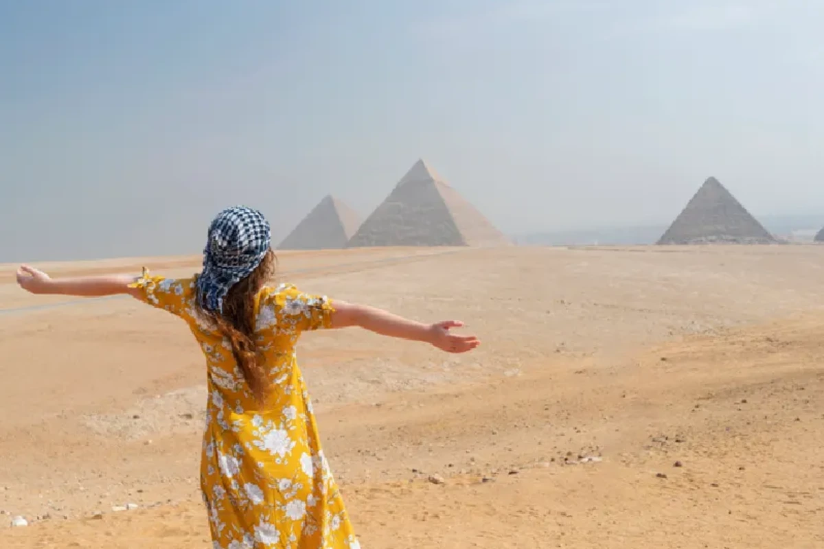 Vista trasera de una turista disfrutando de una visita a las Pirámides de Guiza, Egipto, viajes a el cairo todo incluido