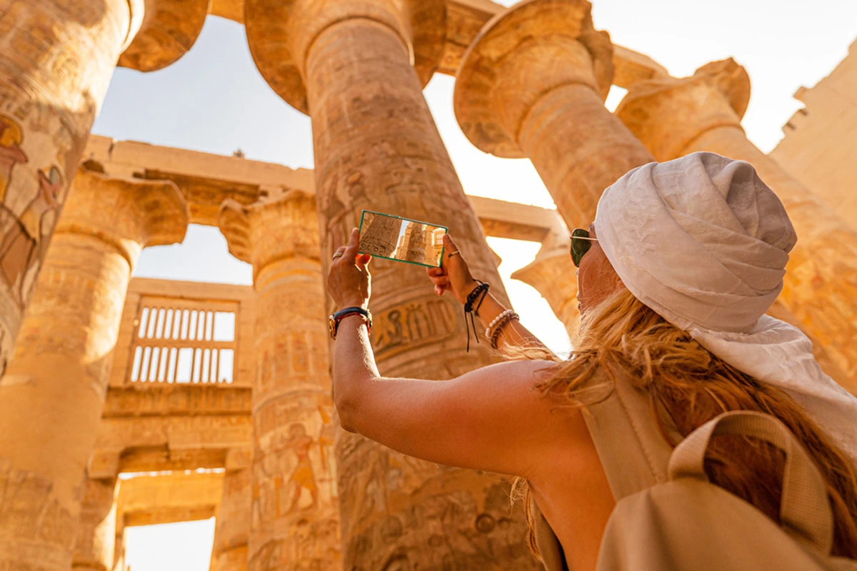 Eine Touristin geht auf der Sphinx-Allee des Karnak-Tempels in Luxor, Ägypten, zwischen den antiken Sphinx-Statuen in Theben.
