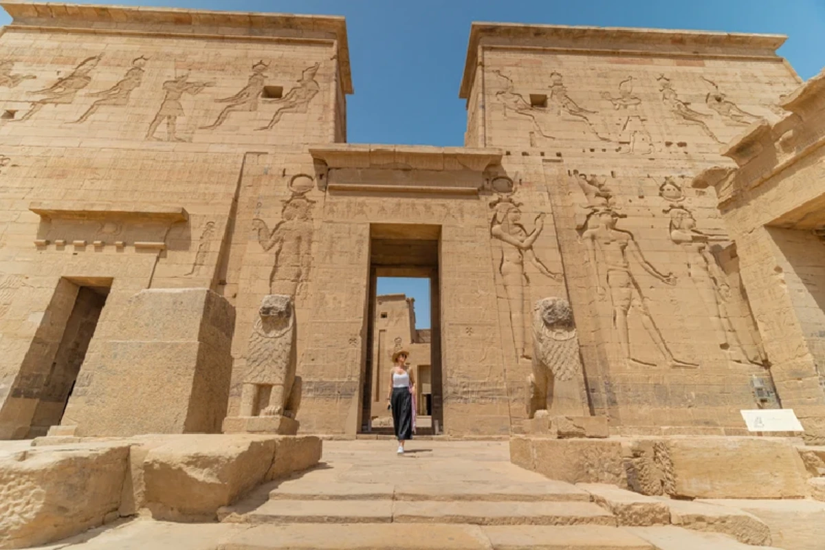 Frau beim Spaziergang durch den Tempel von Philae, auch Tempel der Isis genannt, auf der Insel Agilkia bei Assuan, Ägypten.