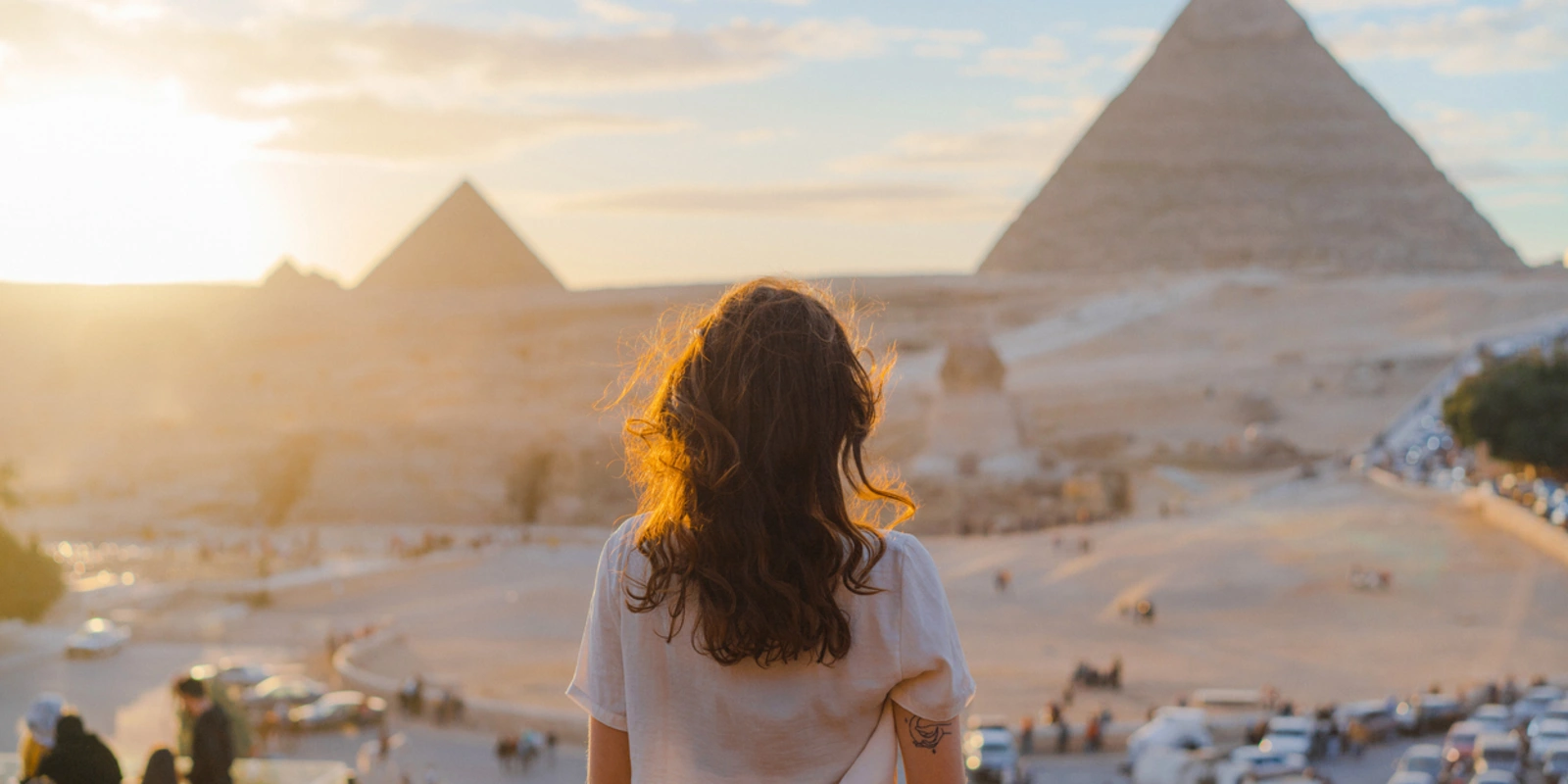 Woman standing on the terrace on the background of Giza pyramids