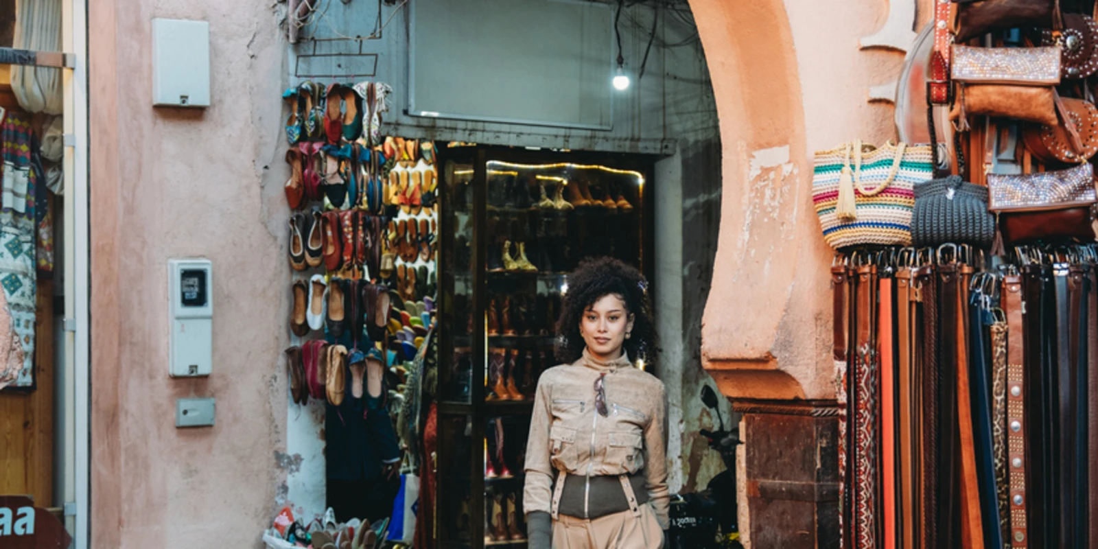 Young adult woman walking through an archway in Marrakech souk