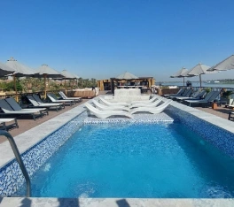 Piscina al aire libre en la cubierta del crucero Le Fayan II, con tumbonas y vistas al río Nilo