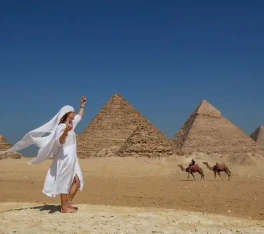 Offerte viaggi Pasqua Egitto, una donna indossa un vestito bianco davanti alle tre piramidi