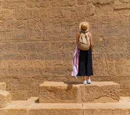Mujer de pie frente al Templo de Filae, también conocido como Templo de Isis, en Asuán, Egipto.