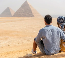 Vista trasera de una pareja que viaja visitando las Pirámides de Giza en Egipto.
