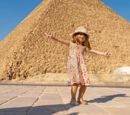 Linda niña bailando frente a la pirámide de Keops en Giza