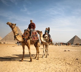 Una familia tomando una foto junto a las pirámides en viaje de lujo a Egipto 