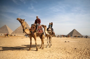 Una familia tomando una foto junto a las pirámides en viaje de lujo a Egipto 
