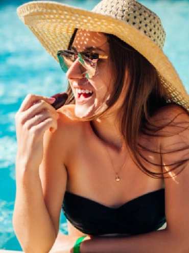 Mujer comiendo fruta y relajándose en la piscina del hotel. Todo incluido en el resort. Vacaciones de verano en Egipto.