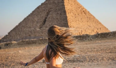 viaggio al cairo, una donna davanti alle piramidi