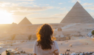 Mujer de pie en la terraza con las pirámides de Giza.