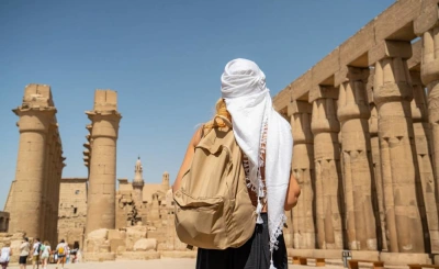 Traveller in a white headscarf standing before the columns of Luxor Temple on a Nile cruise shore excursion