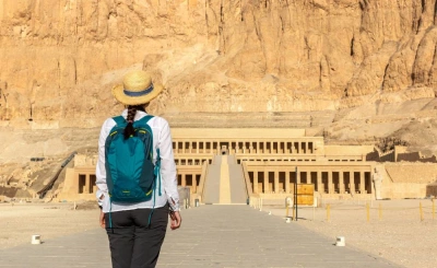 Woman in a straw hat looking at the Temple of Hatshepsut at Deir el-Bahari on the Luxor West Bank