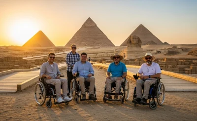  Five wheelchair users pose on a paved path at sunset with the Pyramids of Giza and the Great Sphinx behind them—capturing accessible tourism at Egypt’s iconic heritage site.