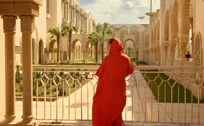 Woman in traditional dress at Hassan II Mosque.