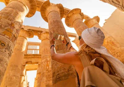 una donna scatta una foto a luxor , tour egitto classico