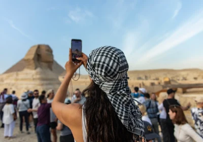 una ragazza scatta una foto delle piramidi, cairo e mare