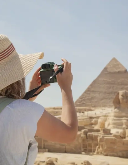 una donna scatta una foto per la piramide , dove andare in egitto a dicembre