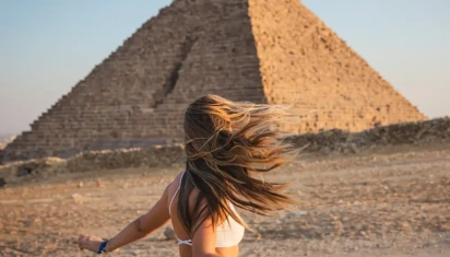 viaggio al cairo, una donna davanti alle piramidi