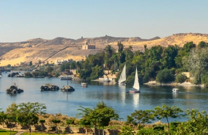 Vista aérea del río Nilo con falucas (barcos de vela tradicionales egipcios) al atardecer en Asuán, Egipto.