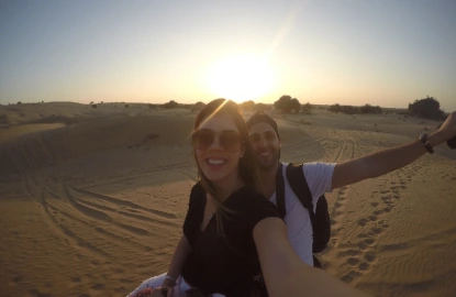 Pareja tomándose un selfie en un camello en el desierto