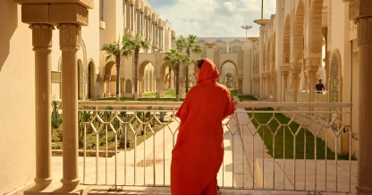 Woman in traditional dress at Hassan II Mosque.