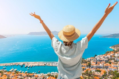 Joyful woman enjoys the stunning view of Kas, a Mediterranean resort town in Turkey, summer in Turkey.