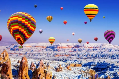 Hot-air balloons float over snow-covered Cappadocia in Turkey