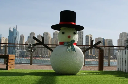 Festive snowman and tree set against Dubai’s skyscrapers and coastline.