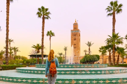 Tourist admiring the Koutoubia Mosque minaret in Marrakech.
