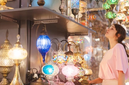 Female traveler admiring colorful lamps in Istanbul’s Grand Bazaar.