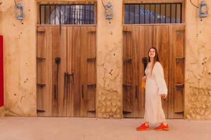 Woman in Arabian dress walking through Al Bastakiya’s historic streets in Dubai.