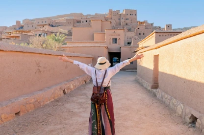 Happy traveler with open arms at Aït Benhaddou in Morocco.